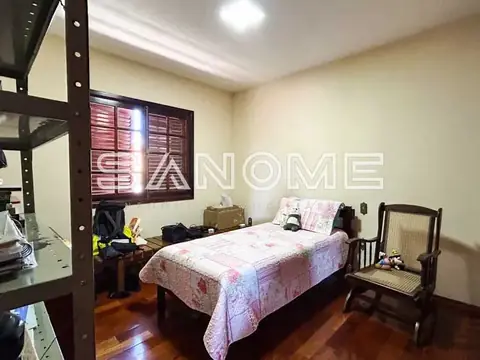 Quarto com cama de casal e móveis em madeira