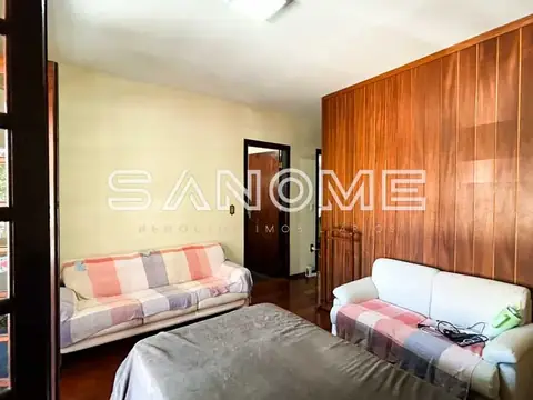 Quarto com cama, sofá e guarda-roupa de madeira