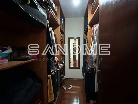 Closet com prateleiras de madeira e roupas penduradas