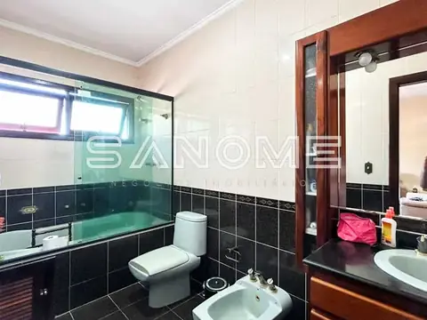 Banheiro com azulejos pretos e bacia sanitária