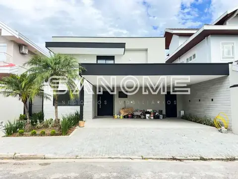 Fachada de casa com garagem e palmeira