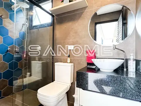 Banheiro com bancada em granito e espelho redondo