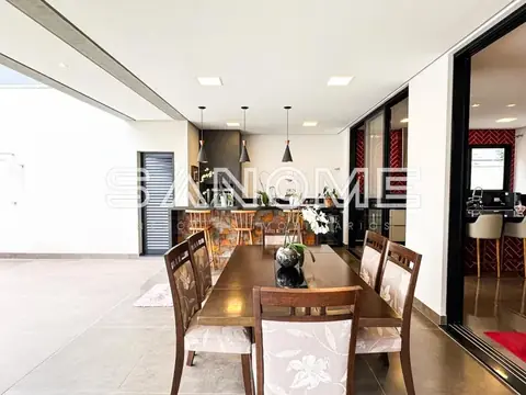 Sala de jantar com mesa de madeira e cozinha integrada
