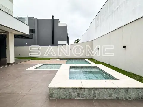 Área externa com piscinas e muro branco