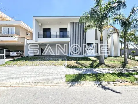 Fachada de casa branca com garagem e palmeiras
