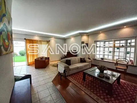 Sala de estar com sofá, poltrona e mesa de vidro