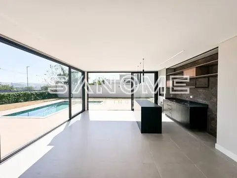 Sala integrada à cozinha com vista para área externa e piscina