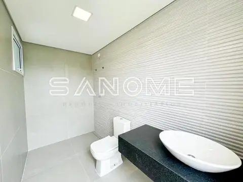 Banheiro com banheira, vaso sanitário e parede texturizada