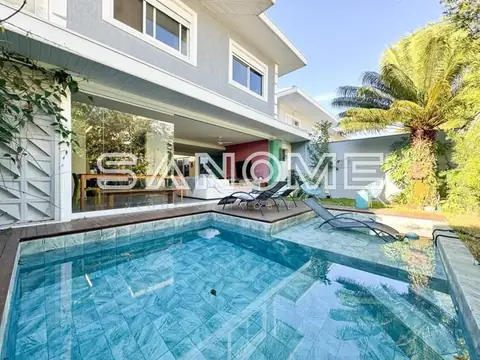 Área externa com piscina e casa ao fundo