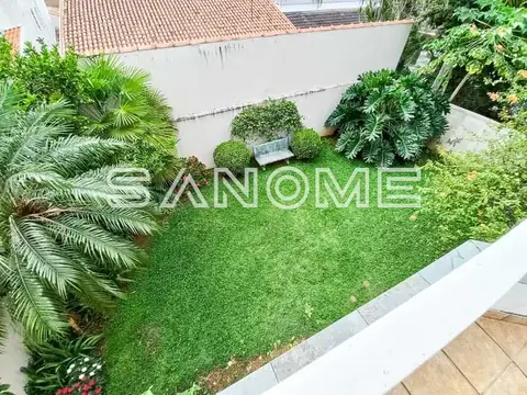 Área externa com gramado e plantas ornamentais