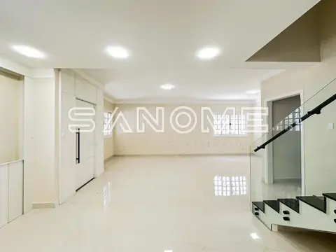 Sala ampla com piso em porcelanato e escada