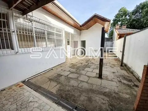Área externa com piso de pedra e garagem