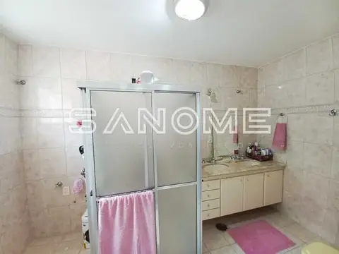 Banheiro com chuveiro, pia e armários