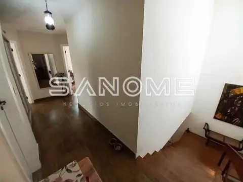Corredor interno com piso de madeira e paredes claras