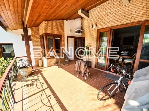 Varanda com piso em cerâmica e acesso à casa