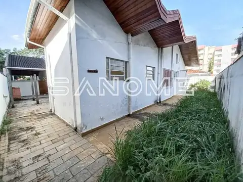 Casa com fachada branca e pátio com grama