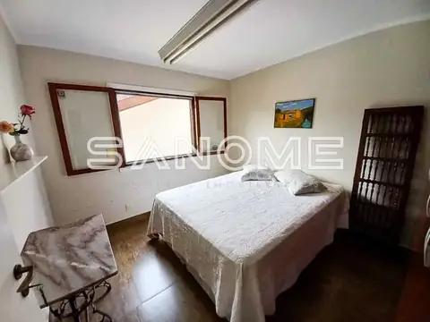 Quarto com cama de casal e espelho grande na parede