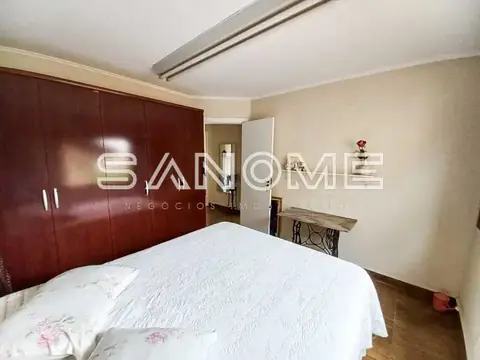 Quarto com cama de casal e guarda-roupa em madeira