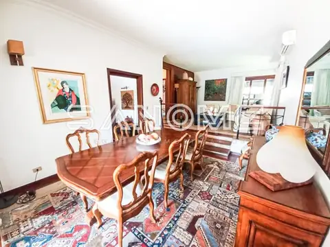 Sala de jantar com mesa de madeira e cadeiras estofadas
