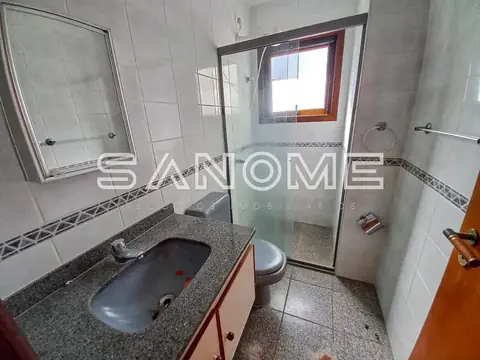 Banheiro com pia, vaso sanitário e box de vidro