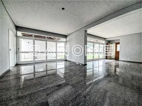 Sala ampla com piso polido e grandes janelas