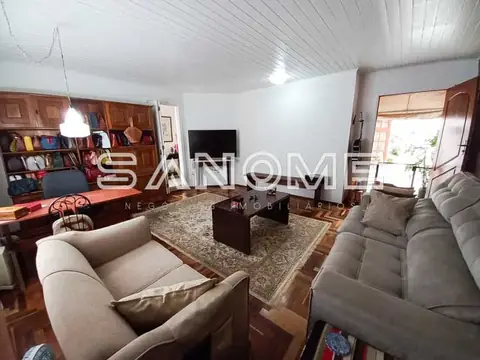 Sala de estar com sofás, TV e estante de madeira
