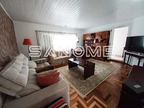Sala de estar com sofá, TV e estante de madeira