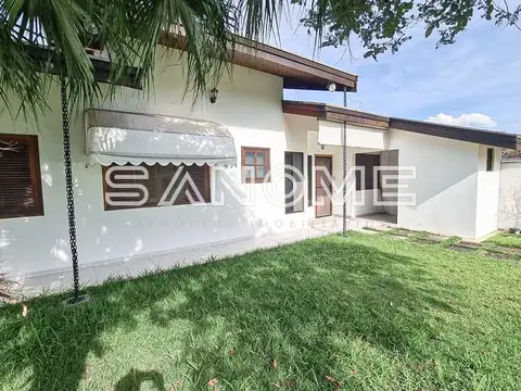 Fachada de casa branca com garagem e gramado