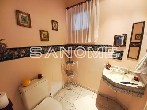 Banheiro com piso cerâmico e pia de granito