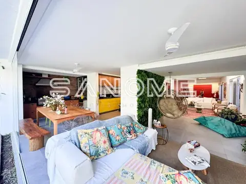 Sala de estar integrada com sofá, mesa de jantar e cozinha