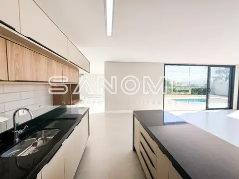 Cozinha planejada com bancada e vista para piscina