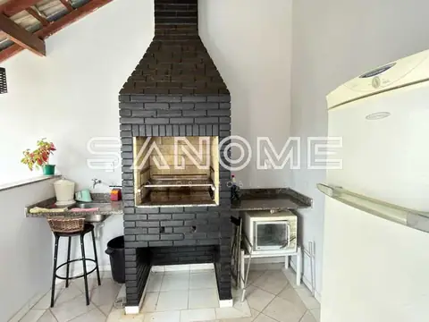 Cozinha com fogão de alvenaria e geladeira