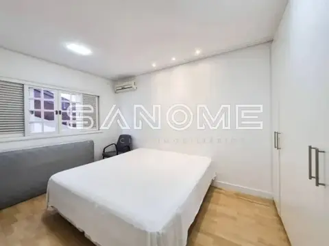 Quarto com cama de casal e mesa de trabalho