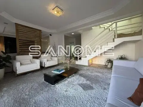 Sala de estar com sofás brancos e escada interna