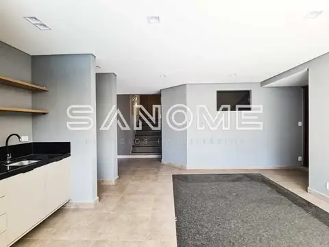 Sala e cozinha integradas com pisos em tons naturais