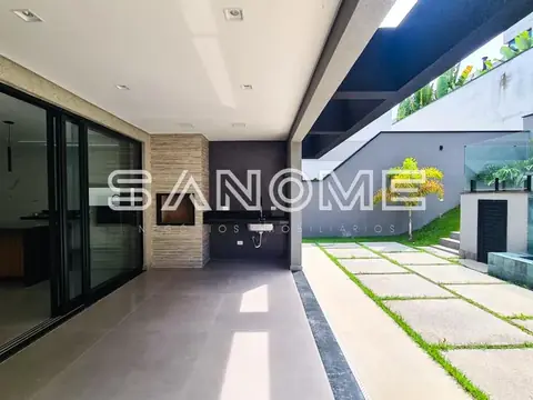 Corredor externo com piso cinzento e acesso à garagem