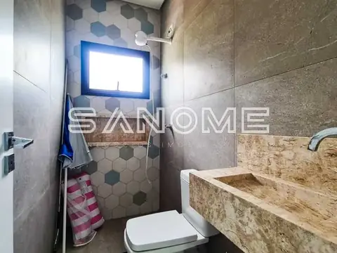 Banheiro com pia em pedra e vaso sanitário