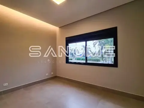 Sala com piso cinzento e janela com vista externa