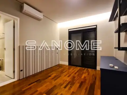 Quarto com piso de madeira e portas pretas