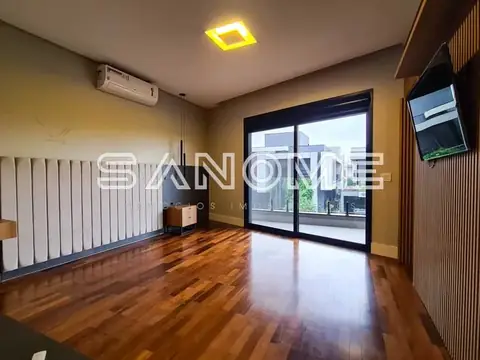 Sala com piso de madeira e varanda com vista externa