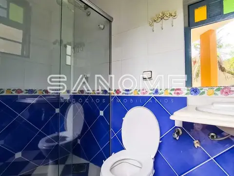 Banheiro com azulejos azuis e box de vidro