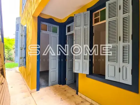 Entrada de casa com portas azuis e amarelo na fachada