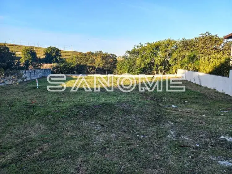 Terreno com grama e árvores ao fundo