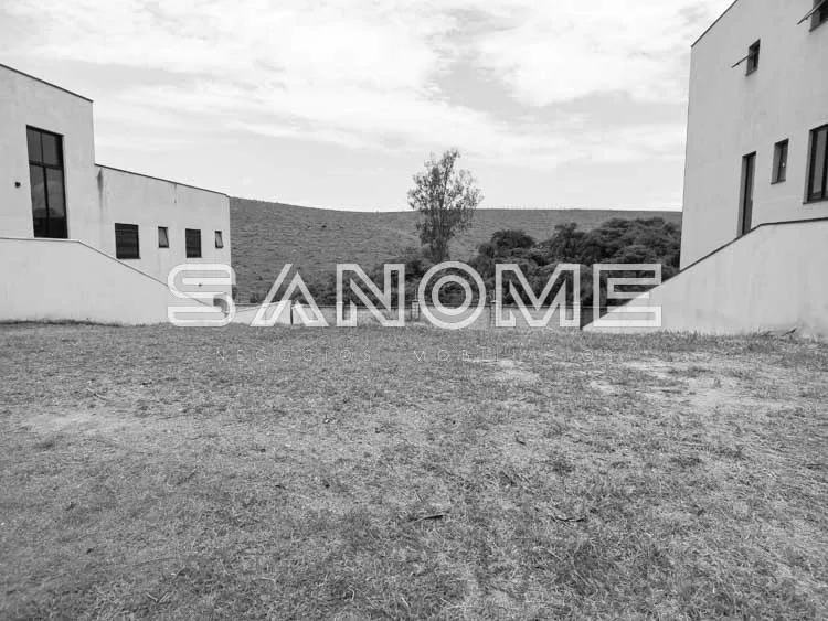Terreno com edificações ao fundo e vegetação