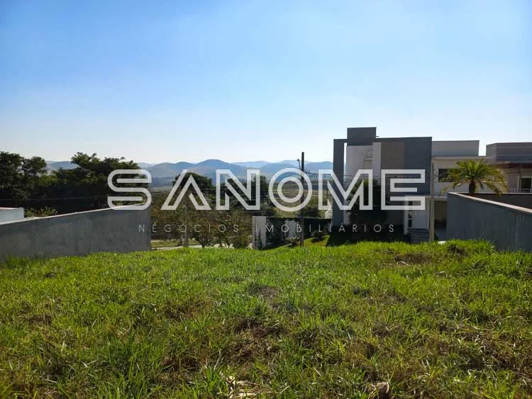 Terreno com construção inacabada e paisagem montanhosa ao fundo