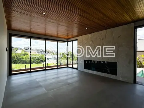 Sala ampla com piso cinzento e janelas panorâmicas