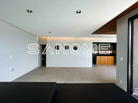 Sala ampla com piso em tons neutros e painel branco