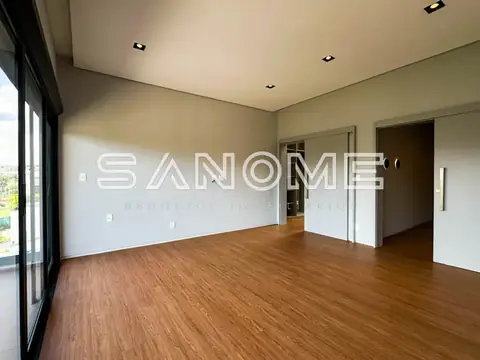 Sala ampla com piso em madeira e grandes janelas