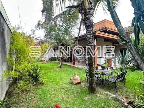 Casa com área externa gramada e palmeiras