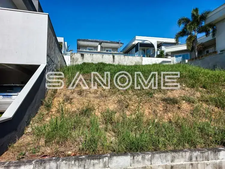 Terreno com vegetação e construções ao fundo